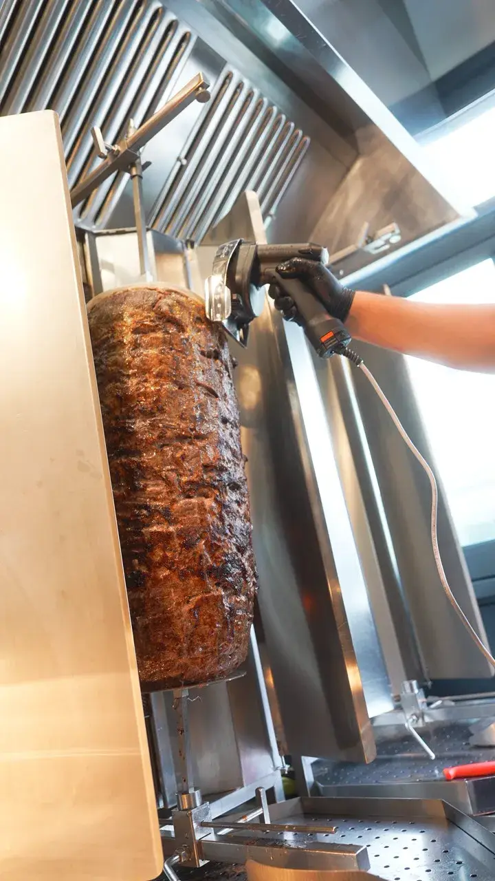 Frisches Färsenfleisch wird vom Dönerspieß geschnitten